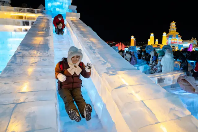 Visitors ride an ice slide at the Harbin International Ice and Snow Festival in Harbin in January 2024.