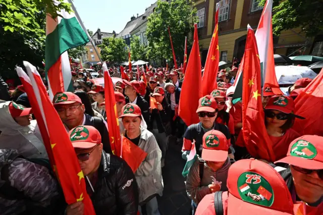 Supporters of China hold Chinese flags in Buda Castle close to the route of Chinese President Xi Jinping's motorcade prior to the Chinese President's meeting with Hungarian Prime Minister Viktor Orban