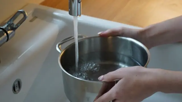 Water coming out of a tap and into a saucepan