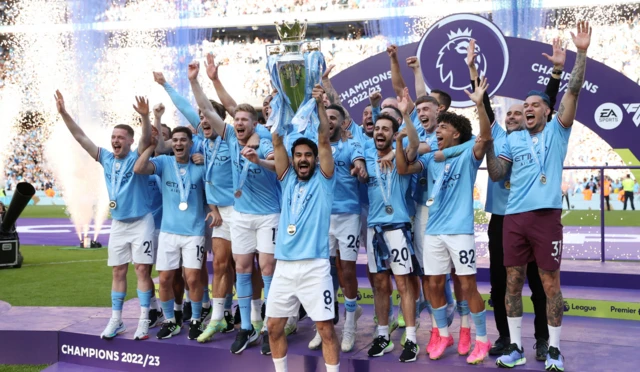 Manchester City players celebrate after being presented with the Premier League trophy in 2023