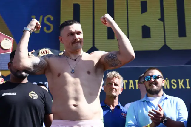 Oleksandr Usyk holds up his arms as his weighs-in to face Daniel Dubois