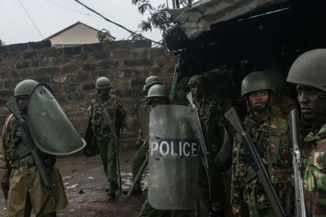 Kenyan police officers watch for rocks thrown by National Super Alliance (NASA) protestors as they attempt to clear the Kibera slum