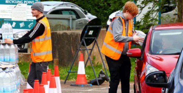 Workers hand out bottled water