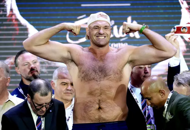 Tyson Fury flexes as he weighs in