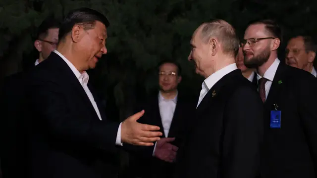 Russian President Vladimir Putin (2R) bids farewell to Chinese President Xi Jinping (L) before his departure to Harbin on the first day of his state visit in Beijing, China