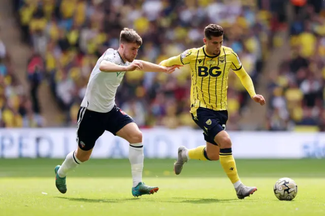 Ruben Rodrigues of Oxford United runs with the ball whilst under pressure from George Thomason of Bolton Wanderers