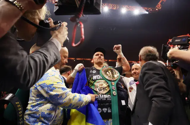 Oleksandr Usyk with his title around his shoulder