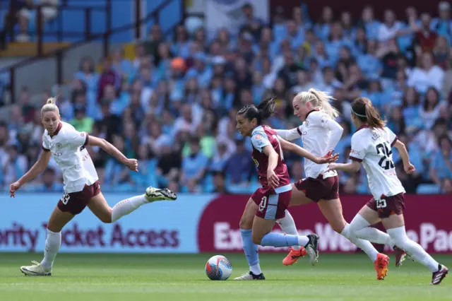 Aston Villa's french midfielder #10 Kenza Dali (C) runs through the City midfield during the English Women's Super League football match between Aston Villa and Manchester City at Villa Park