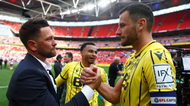 Oxford United head coach Des Buckingham (L) celebrates with Elliott Moore