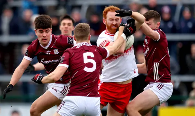 Derry's Conor Glass is challenged by two Galway players