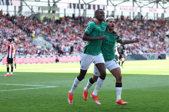 Alexander Isak of Newcastle United celebrates scoring his team's third goal with teammate Bruno Guimaraes during the Premier League match between Brentford FC and Newcastle United at Brentford Community Stadium