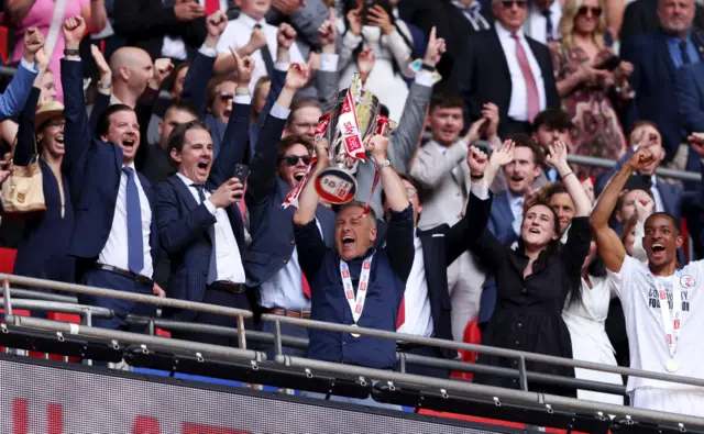 Crawley manager Scott Lindsey lifts the League Two play-off trophy