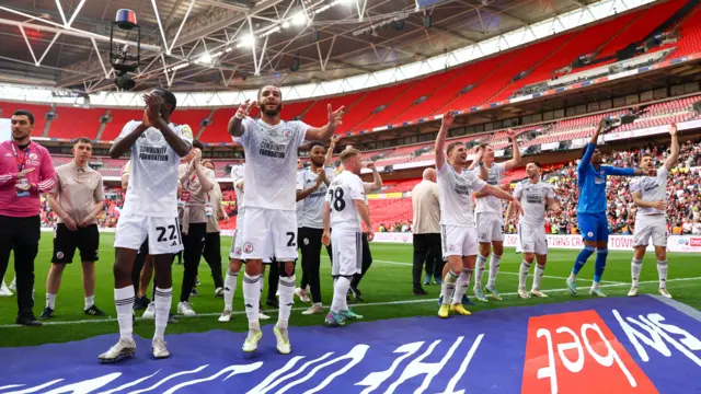 Crawley players celebrate winning promotion to League One