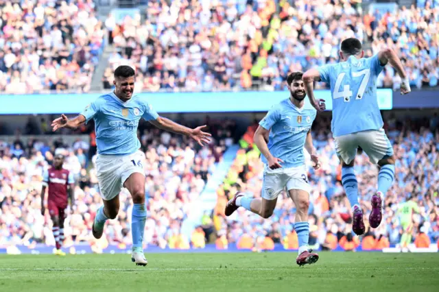 Manchester City's Spanish midfielder #16 Rodri (L) celebrates scoring the team's third goal during the English Premier League football match between Manchester City and West Ham United at the Etihad Stadium