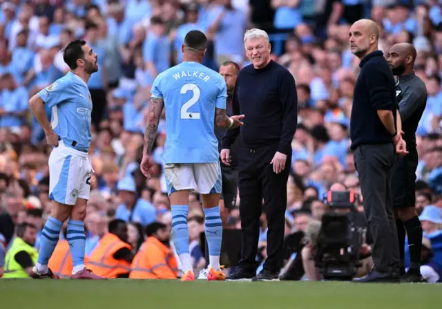 West Ham United's Scottish manager David Moyes (C) talks with Manchester City's Portuguese midfielder #20 Bernardo Silva (L) and Manchester City's English defender #02 Kyle Walker during the English Premier League football match between Manchester City and West Ham United at the Etihad Stadium