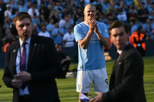 Manchester City's Norwegian striker #09 Erling Haaland applauds the fans as he waits for the Premier League trophy presentation ceremony following the English Premier League football match between Manchester City and West Ham United at the Etihad Stadium