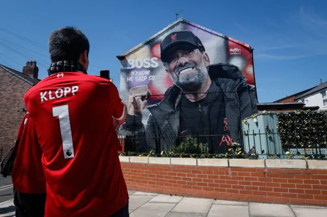 Liverpool fans take pictures of a mural of Jurgen Klopp the head coach / manager of Liverpool before the Premier League match between Liverpool FC and Wolverhampton Wanderers at Anfield