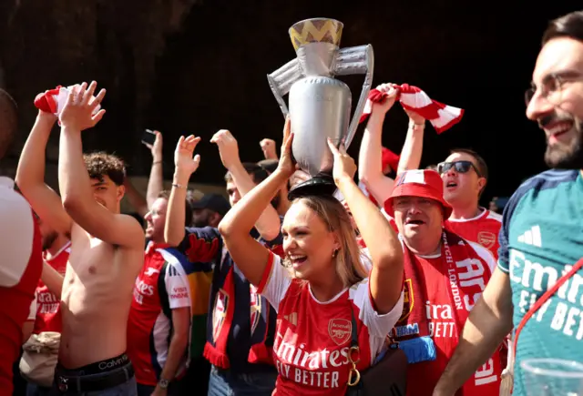 An Arsenal fan holds up a inflatable Premier League trophy prior to the Premier League match between Arsenal FC and Everton FC at Emirates Stadium on May 19