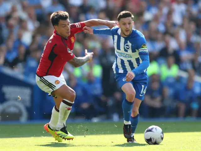 Adam Lallana of Brighton & Hove Albion is challenged by Lisandro Martinez of Manchester United during the Premier League match between Brighton & Hove Albion and Manchester United at American Express Community Stadium