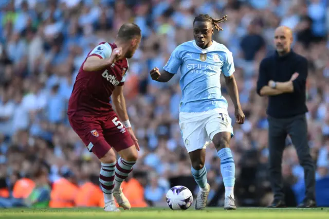 Jeremy Doku of Manchester City runs with the ball whilst under pressure from Vladimir Coufal of West Ham United during the Premier League match between Manchester City and West Ham