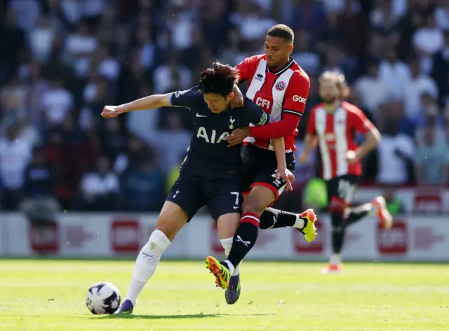 Son Heung-Min of Tottenham Hotspur is challenged by Vinicius Souza of Sheffield United during the Premier League match between Sheffield United and Tottenham Hotspur at Bramall Lane