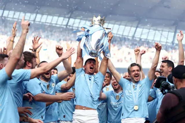 Matheus Nunes of Manchester City lifts The Premier League Trophy as he celebrates with teammates on the stage after the Premier League match between Manchester City and West Ham United at Etihad Stadium