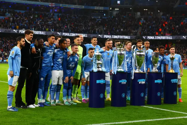 Manchester City pose with all five trophies they won during the calendar year 2023 ahead of the Premier League match between Manchester City and Sheffield United at Etihad Stadium