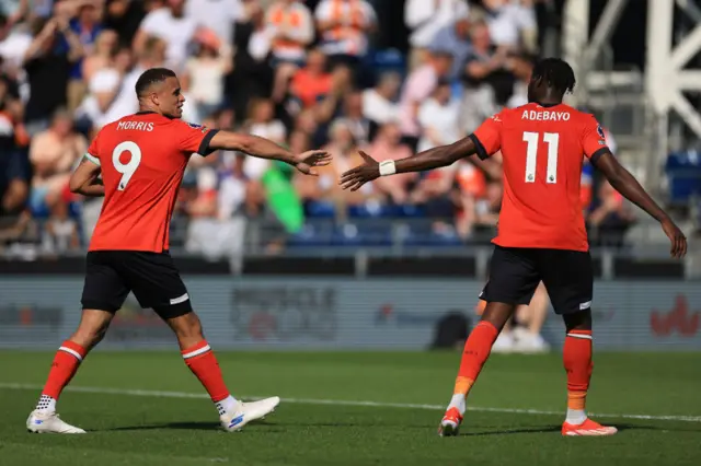 Carlton Morris of Luton Town celebrates scoring his team's first goal with teammate Elijah Adebayo during the Premier League match between Luton Town and Fulham FC