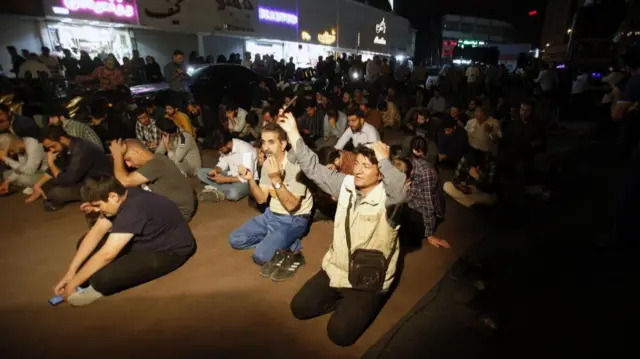 Groups of men seen kneeling in prayer for President Ebrahim Raisi on the streets of Tehran, Iran