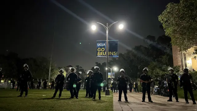 A row of police officers stand on the UCLA campus