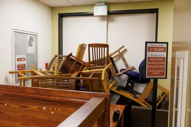 A pile of furniture stacked in front of a door barricading protesters in the Portland State University library