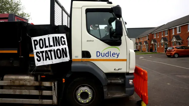 A sign for a polling station on the side of a truck