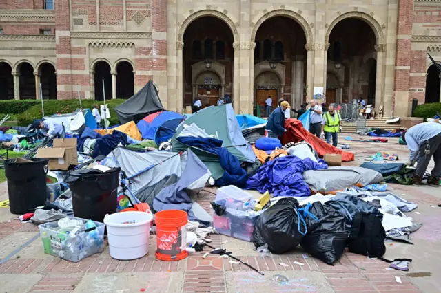 Workers clean up the University of California, Los Angeles (UCLA) campus after police evicted pro-Palestinian students, in Los Angeles, California, early on May 2, 2024. Hundreds of police tore down protest barricades and began arresting students early Thursday at the University of California, Los Angeles