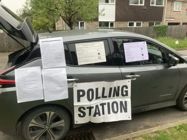 A car with polling station cards stuck to it