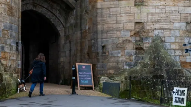 A woman walking her dog enters Tonbridge Castle