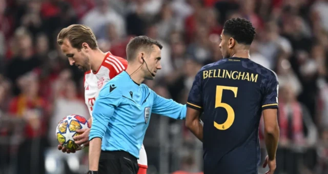 Jude Bellingham speaks to Harry Kane as he prepares to take a penalty for Bayern Munich