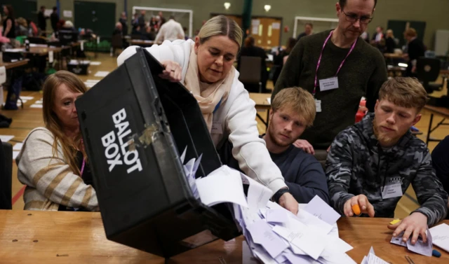 An election official empties a ballot box to count the votes, during the Blackpool South Parliamentary by-election