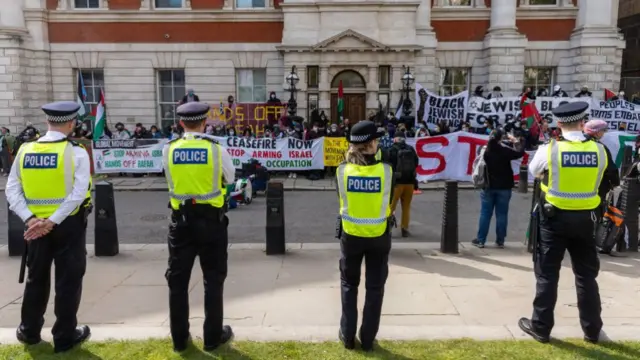 Metropolitan Police officers monitor pro-Palestinian activists taking part in a May Day protest in London.