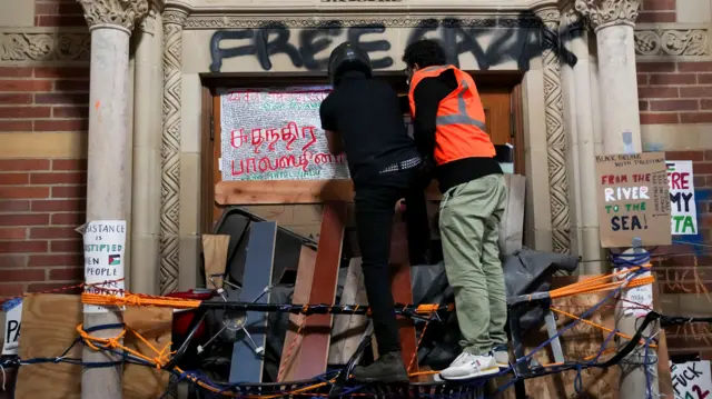 Two protesters setting up a blockade at a UCLA building.