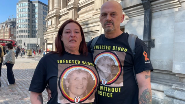 Two people wear t-shirts showing a photo of a blood scandal victim.