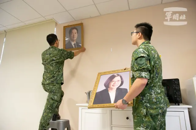 An officer replaces Tsai's portrait with that of Lai