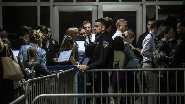 Reporters wait in the hallway after they were told to leave the courtroom by the judge