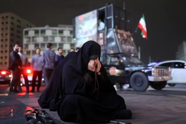 woman prays for Raisi in Tehran