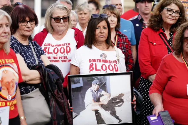 Campaigners held up pictures of loved ones who died after being treated with contaminated blood products