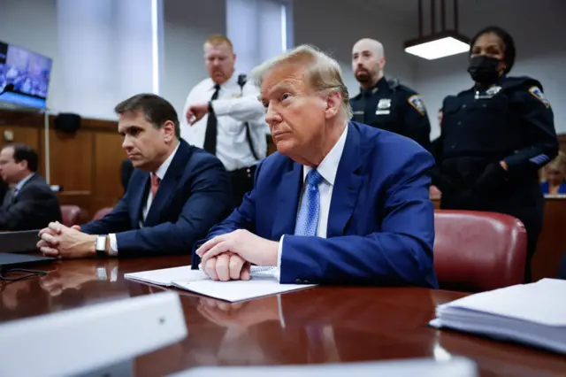 Donald Trump sits at the defence desk with his lawyer Todd Blanche