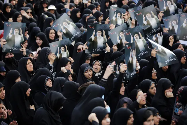 Iranian women hold posters of Raisi as they take part in a mourning ceremony in Tehran, 20 May 2024