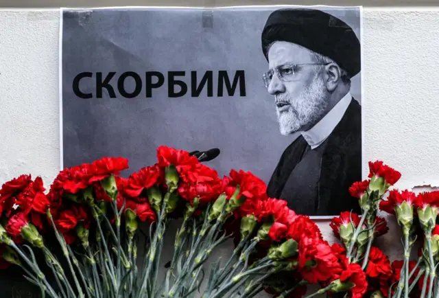 The portrait of the late Iranian President Ebrahim Raisi is displayed among flowers laid outside the Iranian embassy in Moscow