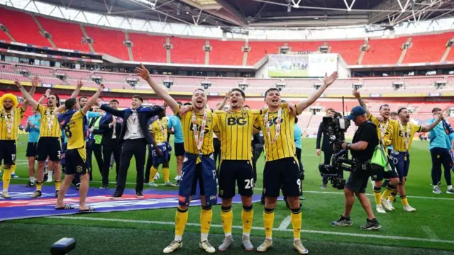 Oxford United fans celebrate on the Wembley pitch