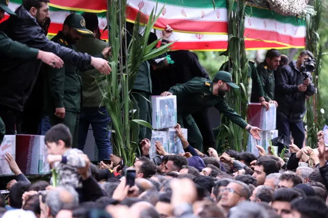 Mourners crowded around an open truck displaying photos of late president Raisi.