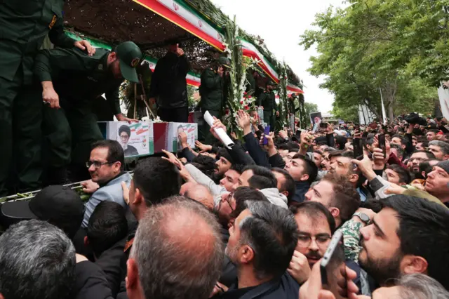 Mourners reach their hands out in the city of Tabriz as a funeral procession carrying the caskets of the late president and seven others marches through the city of Tabriz.